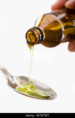 Close-up of a person's hand dans une cuillère sirop Banque D'Images