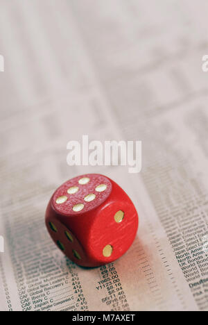High angle view of a dice on stock market data sheet Banque D'Images