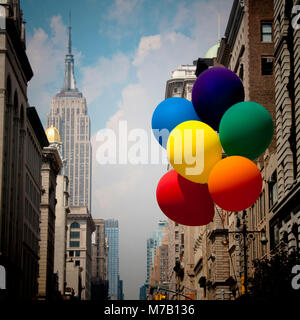 Ballons de couleur arc-en-ciel en face de bâtiments, l'Empire State Building, New York City, New York State, USA Banque D'Images