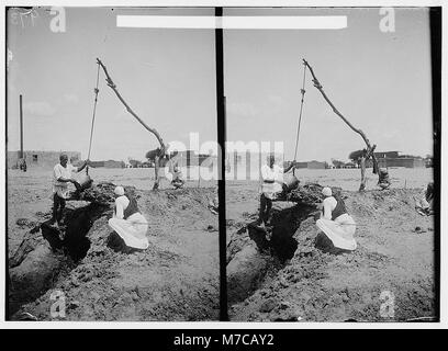 Photographie représentant des personnages égyptiens anciens et leurs techniques d'irrigation primitives. L'image donne un aperçu des premières méthodes de gestion de l'eau et des pratiques agricoles dans l'Egypte ancienne. Banque D'Images