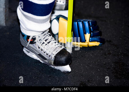 La section basse vue d'un joueur de hockey sur glace Hockey sur glace permanent avec un bâton et un gant Banque D'Images