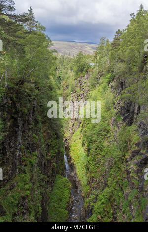 Braemore, ÉCOSSE - 8 juin 2012 : Corrieshalloch Gorge est une profonde coupure en mode paysage boisé avec des pentes verticales sous cloudscape gris. Banque D'Images