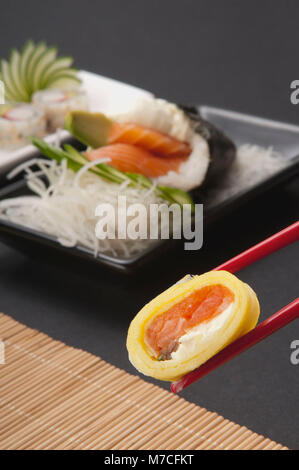 Close-up of sushi tenu avec des baguettes Banque D'Images