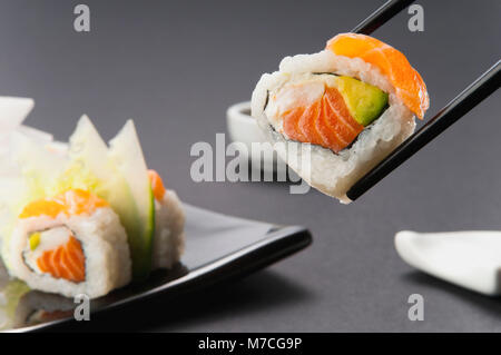 Close-up of sushi tenu avec des baguettes Banque D'Images