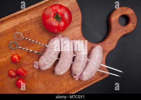 Portrait de saucisses dans les brochettes sur planche à découper Banque D'Images