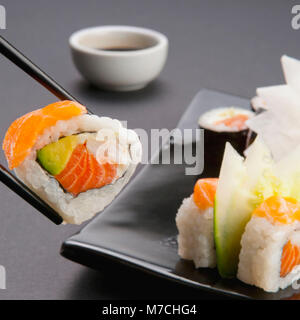 Close-up of sushi tenu avec des baguettes Banque D'Images