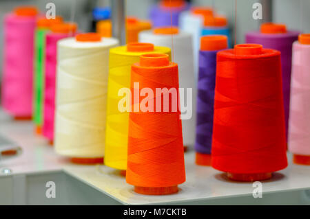 Plusieurs bobines de filetage coloré prêtes pour la machine monograme. Banque D'Images