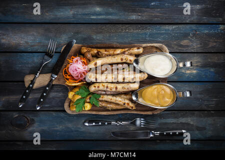 Saucisse fumée avec de la choucroute et les quartiers de pommes de terre. Banque D'Images