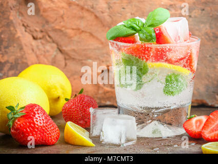 L'été une rafraîchissante limonade. Boire avec du citron, fraises, menthe, basilic et glace. Detox. L'eau minérale. Selective focus Banque D'Images
