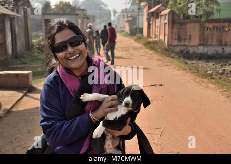 Belle jeune fille tenant un chiot dans la rue sa main outdoor Banque D'Images