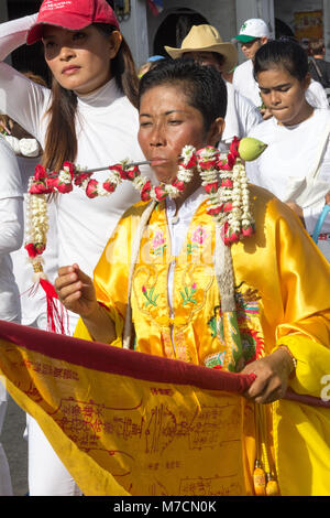 Femme avec une broche à travers sa joue dans un défilé pendant les neuf dieux empereur festival (festival végétarien) à Phuket, Thaïlande Banque D'Images