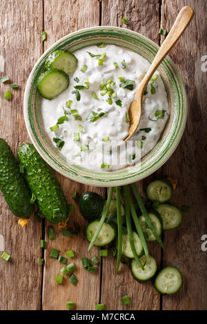 Sauce épicée indienne raita de concombre aux herbes et close-up dans un bol sur la table. Haut Vertical Vue de dessus Banque D'Images