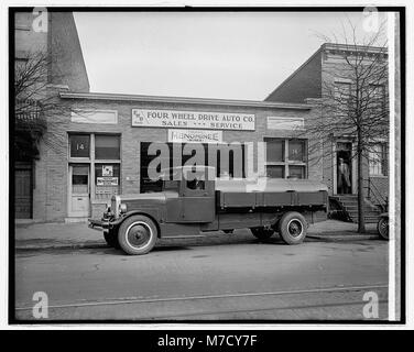 Cette image montre un camion pétrolier de la quatre roues motrices Auto Co., reflétant le transport commercial du début du XXe siècle et l'essor des systèmes de livraison motorisés dans l'industrie. Banque D'Images
