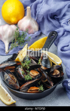 Coquilles de moules au délicieux dans la vinaigrette au citron et à l'ail avec le thym. Les fruits de mer d'épices. Apéritif gourmet. Selective focus Banque D'Images