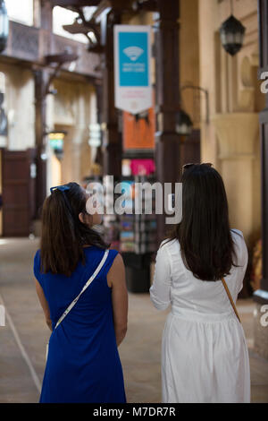 Vue arrière de l'intérieur les touristes femmes Souk Madinat Jumeirah Dubai UAE Banque D'Images