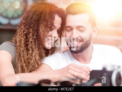 Heureux couple aimant en utilisant un smartphone assis en terrasse Banque D'Images