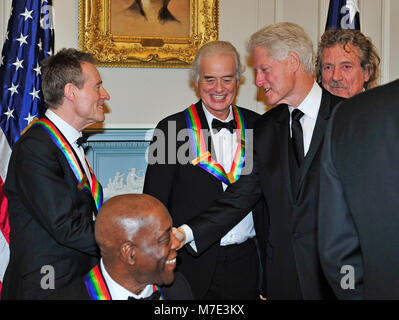 John Paul Jones de Led Zeppelin, l'un des sept lauréats du 2012 Kennedy Center Honors, serre la main avec l'ancien Président des États-Unis Bill Clinton en tant que collègues lauréats Jimmy Page, Robert Plant et Buddy Guy rechercher sur comme ils se préparent à poser pour une photo à la suite d'un dîner organisé par le secrétaire d'État des États-Unis, Hillary Rodham Clinton au département d'État des États-Unis à Washington, D.C. le samedi, Décembre 1, 2012. Les lauréats 2012 sont Buddy Guy, l'acteur Dustin Hoffman, l'hôte en fin de soirée David Letterman, danseur, Natalia Makarova et le groupe de rock britannique Led Zeppelin (Robert Plant, Jimm Banque D'Images