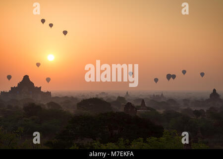 Belle vue sur de nombreux ballons à air plus de temples et pagodes à la plaine de Bagan au Myanmar (Birmanie) au lever du soleil. Banque D'Images