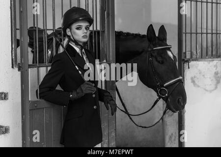 Retro photo. Modèle à la mode dans l'équipement, posant en troupeau pour hourses. Tourné à l'intérieur, le sport et la mode concept. Banque D'Images