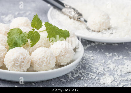 Des bonbons de coco dans une assiette blanche sur la table. Des bonbons. Selective focus Banque D'Images