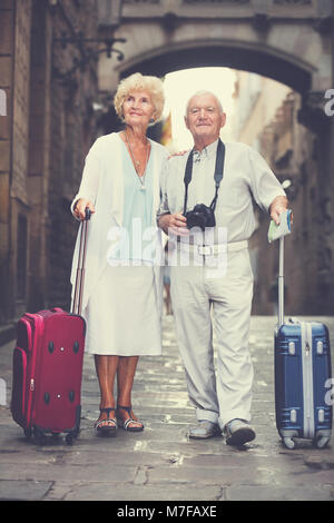 Voyages conjoints matures debout devant l'ancienne cathédrale avec une carte et l'appareil photo Banque D'Images