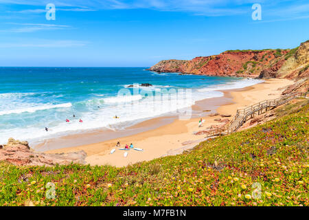 Surfers sur belle plage Praia do Amado, endroit populaire pour faire des sports nautiques, Algarve, Portugal Banque D'Images
