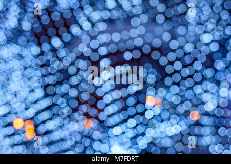 Arrière-plan flou bleu néon,, beaucoup de petits cercles bokeh avec quelques points orange, motif texture Banque D'Images
