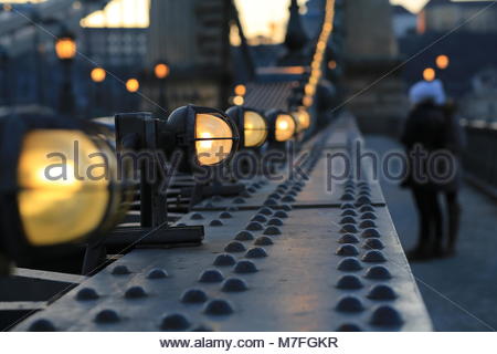 Lampes sur un pont à Budapest , Hongrie, briller comme tombée du jour tombe sur la ville. Banque D'Images