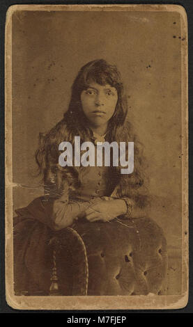 Un portrait de trois quarts d'une femme non identifiée, posée derrière une chaise, capturé par A.H. Plecker. Cette photographie, prise à Lynchburg, en Virginie, offre un aperçu du portrait et de la mode du début du XXe siècle. Banque D'Images