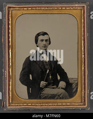 Photographie d'un homme non identifié tenant une canne, capturée dans une photographie de style vintage, sans autre contexte sur son identité. Banque D'Images