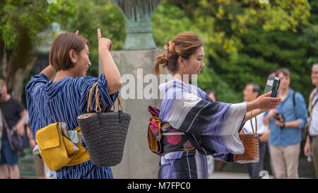 Deux jeunes femmes prenant une belle japonaise habillée de façon traditionnelle selfies yukata d'été à Kamakura au Japon. Banque D'Images