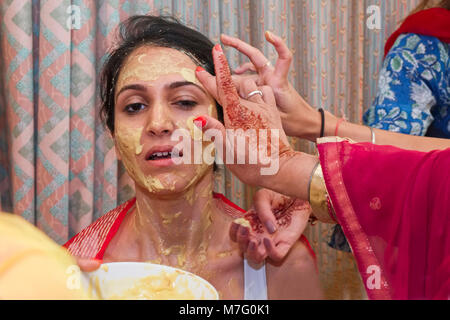 Cérémonie de mariage indien bénédiction avant d'être mariée avec la pâte de curcuma enduite sur le visage par des parents Banque D'Images