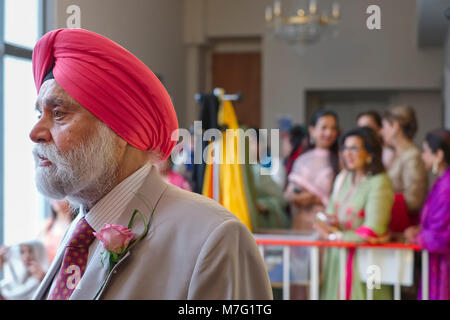 L'homme dans le gurdwara attente de l'arrivée des mariés à un mariage sikh indien Banque D'Images