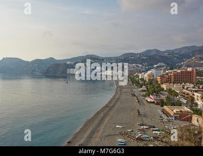 Almunica plage et bord de mer en Andalousie, espagne. Certaines personnes s'asseoir sur la plage pour regarder le coucher du soleil sur la mer méditerranée. Banque D'Images