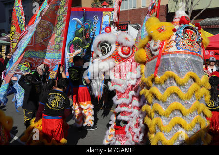 À la tête de la parade du Nouvel An chinois à San Diego, les hommes tiennent des bannières colorées et effectuer la danse en costumes lion le long de la route de la ville. Banque D'Images