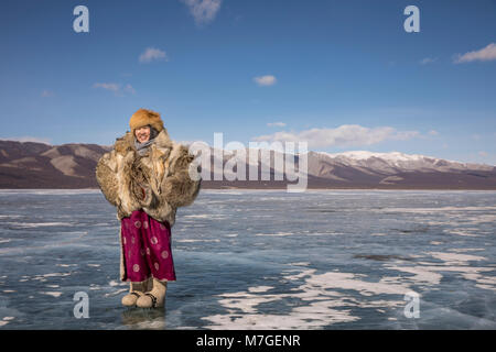 Jeune Dame en Mongolie wolfskin veste sur un lac gelé Khövsgöl dans le nord de la Mongolie Banque D'Images