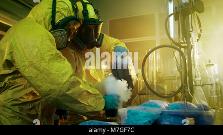 Dans le laboratoire de drogue souterrain deux chimistes clandestins de mélanger les produits chimiques pendant la cuisson des stupéfiants. Ils utilisent des cartouches et des béchers, des composés toxiques. Banque D'Images