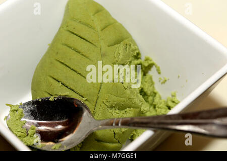 Wasabi vert feuille dans un bol blanc avec cuillère Banque D'Images