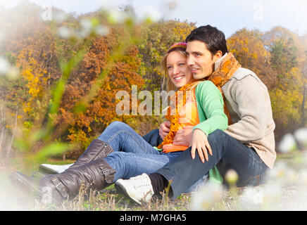 Sweet couple assis sur une colline et en regardant le paysage d'automne.Automne set. Banque D'Images