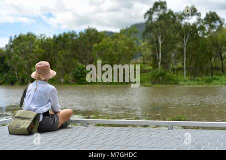 Femme regarde à travers une rivière, Apex Park Drive, Condon Riverway, QLD, Australie Banque D'Images