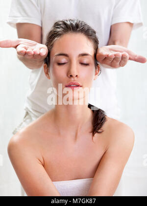 Jolie jeune femme qui reçoit un massage de la tête au salon de Banque D'Images