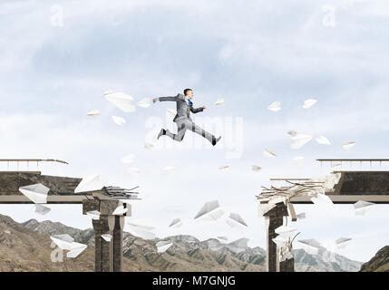 Businessman jumping over gap en pont entre flying paper planes comme symbole de surmonter les difficultés. Skyscape et nature vue sur arrière-plan. 3D render Banque D'Images