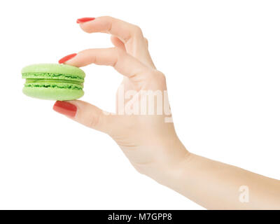 Main femme avec du vernis à ongles rouge petit macaron vert soigneusement tenue. Isolé sur blanc, chemin de détourage inclus Banque D'Images