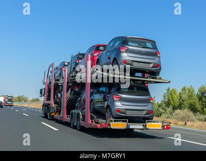 Grande voiture avec remorque porte-voitures sur la plate-forme superposés. Transport de voiture camion sur l'autoroute Banque D'Images