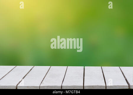 Fond vert naturel avec focus sélectif. Le fond vert a une feuille d'herbe et de flou sur un plancher en bois blanc. Table en bois de l'espace vide vide Banque D'Images
