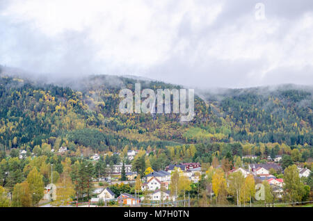 Vue à longue distance d'Evje cityline dominé par des montagnes de basse couverte par la forêt et les nuages, le centre de la Norvège, de l'Europe. Banque D'Images