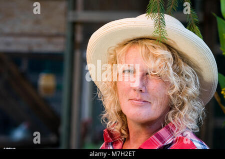 Les outdoor tête portrait of a middle-aged woman in straw hat smiling friendly à l'appareil photo. Banque D'Images