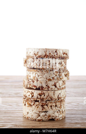 Pile d'alimentation crispbreads sur table en bois léger, close-up, selective focus. Composition de riz soufflé, certains snack espace copie. Studio shot. Un sain Banque D'Images