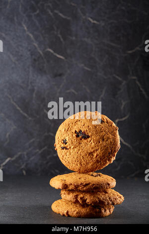 Lowkey photo de chocolate chip cookies sur marbre foncé background, close-up, profondeur de champ, à la verticale. Banque D'Images