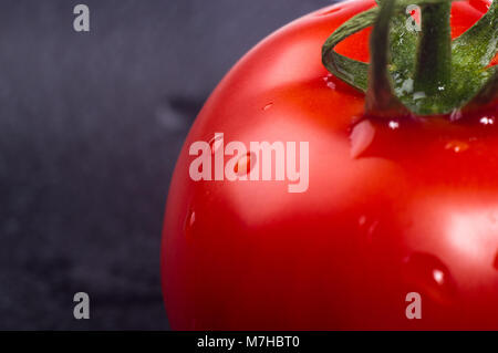 Tomates mûres fraîches sur fond noir, macro photo Banque D'Images